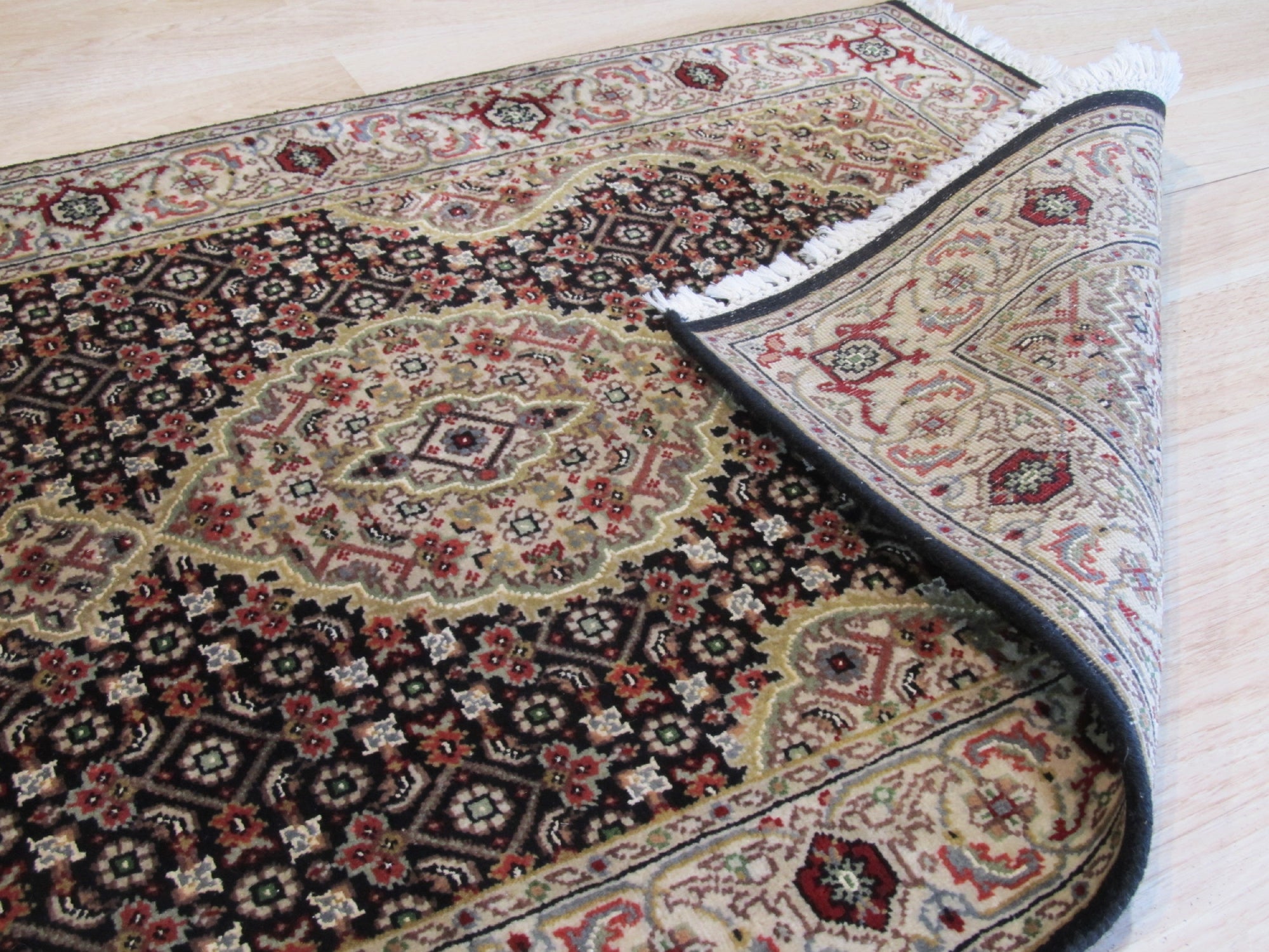 Elena Versatile Brown Hand Knotted Wool Rug, textured wool pile and subtle pattern visible under soft light, displaying its warm brown tones within a showroom setting.