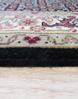 Ophelia Amara Brown Hand Knotted Wool Rug, a warm brown hand-knotted wool rug with subtle geometric patterns, partially visible in a styled living room setting.