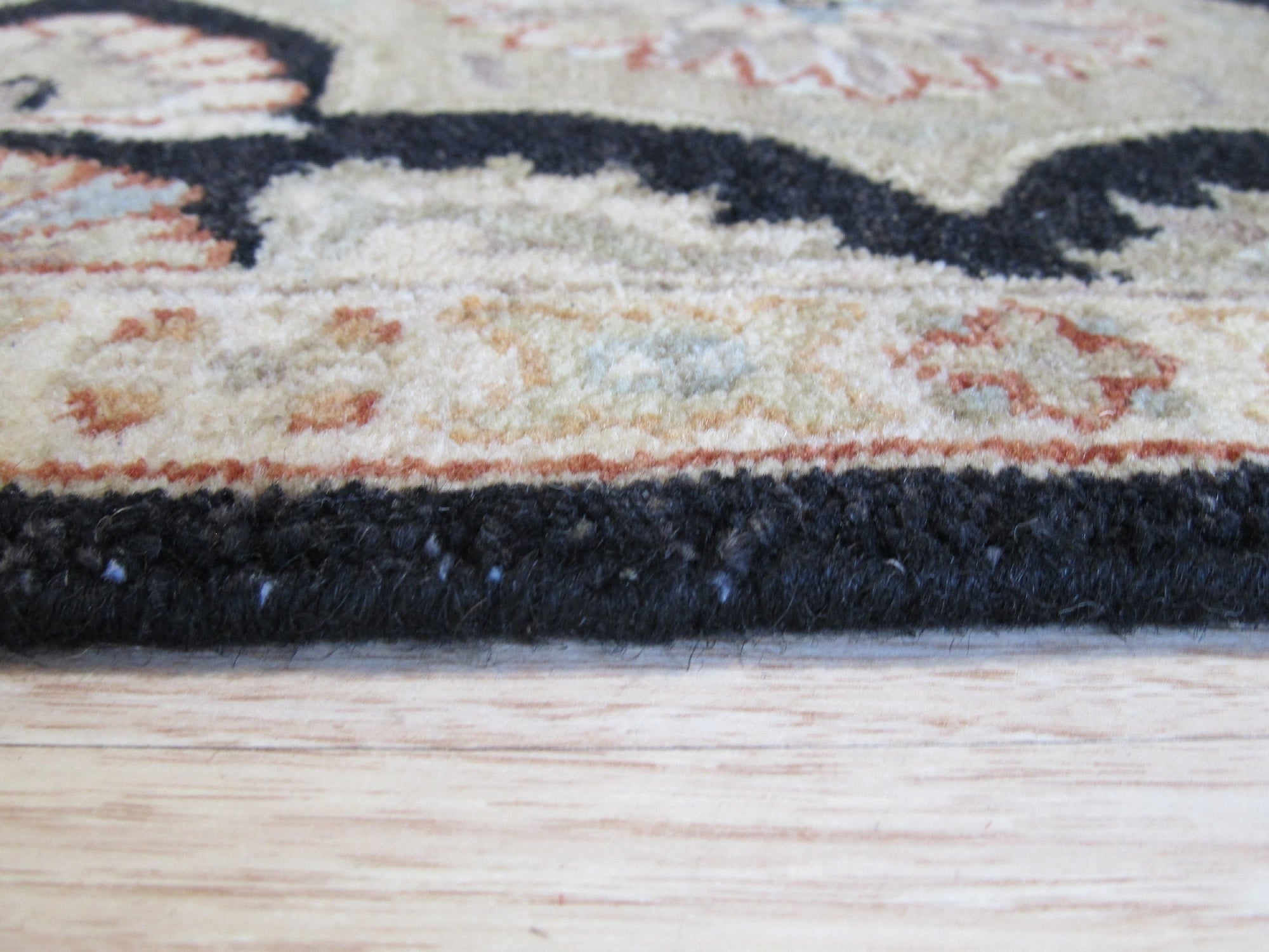 Timeless Agra Black Hand Knotted Wool Rug, showcasing its intricate hand-knotted construction and deep black wool fibers within a warmly lit interior setting.