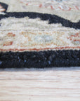 Timeless Agra Black Hand Knotted Wool Rug, showcasing its intricate hand-knotted construction and deep black wool fibers within a warmly lit interior setting.