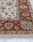 Exquisite Agra Multicolor Hand Knotted Wool Rug, a vibrant array of blues, reds, greens, and yellows woven into a detailed pattern, displayed within a warmly lit living space featuring contemporary furniture.