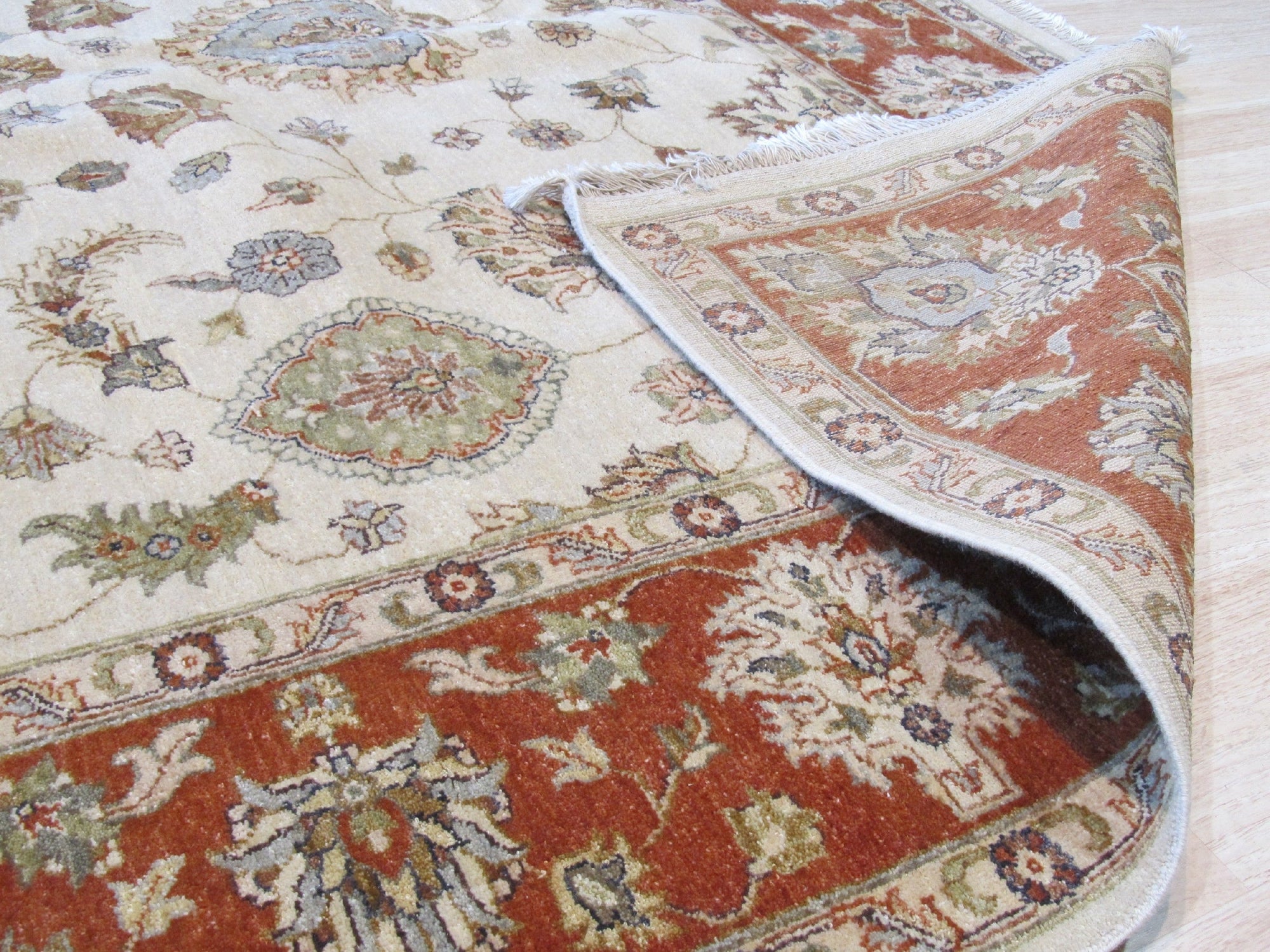 Exquisite Agra Multicolor Hand Knotted Wool Rug, its vibrant reds, blues, greens, and golds creating an intricate floral pattern, resting on a light hardwood floor, adding warmth and texture to the room.