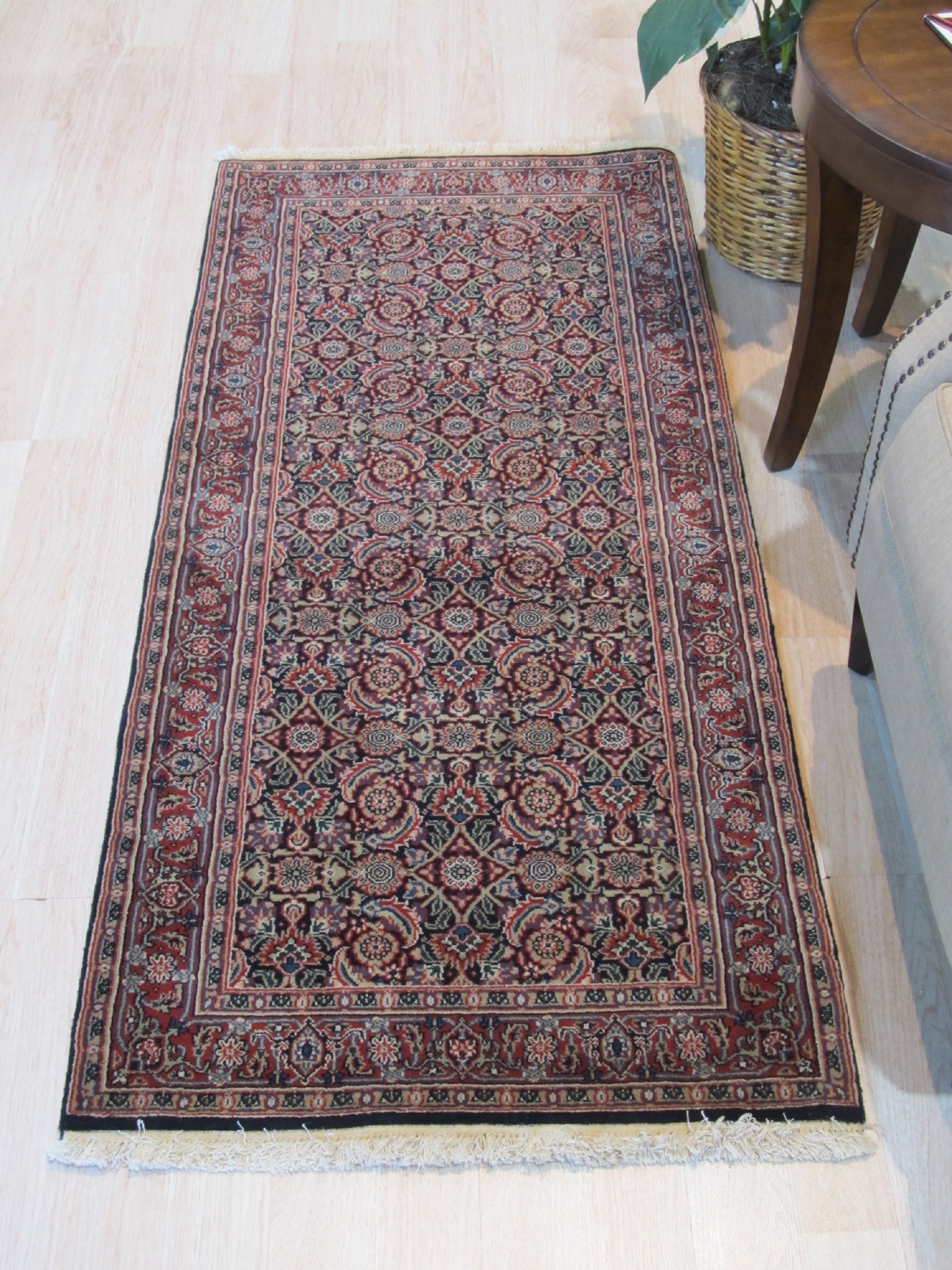 Sleek Oriental Navy Hand Knotted Wool Rug, its intricate pattern unfolding across a deep navy field, hand-knotted wool adding texture to the refined design, displayed in a room setting.