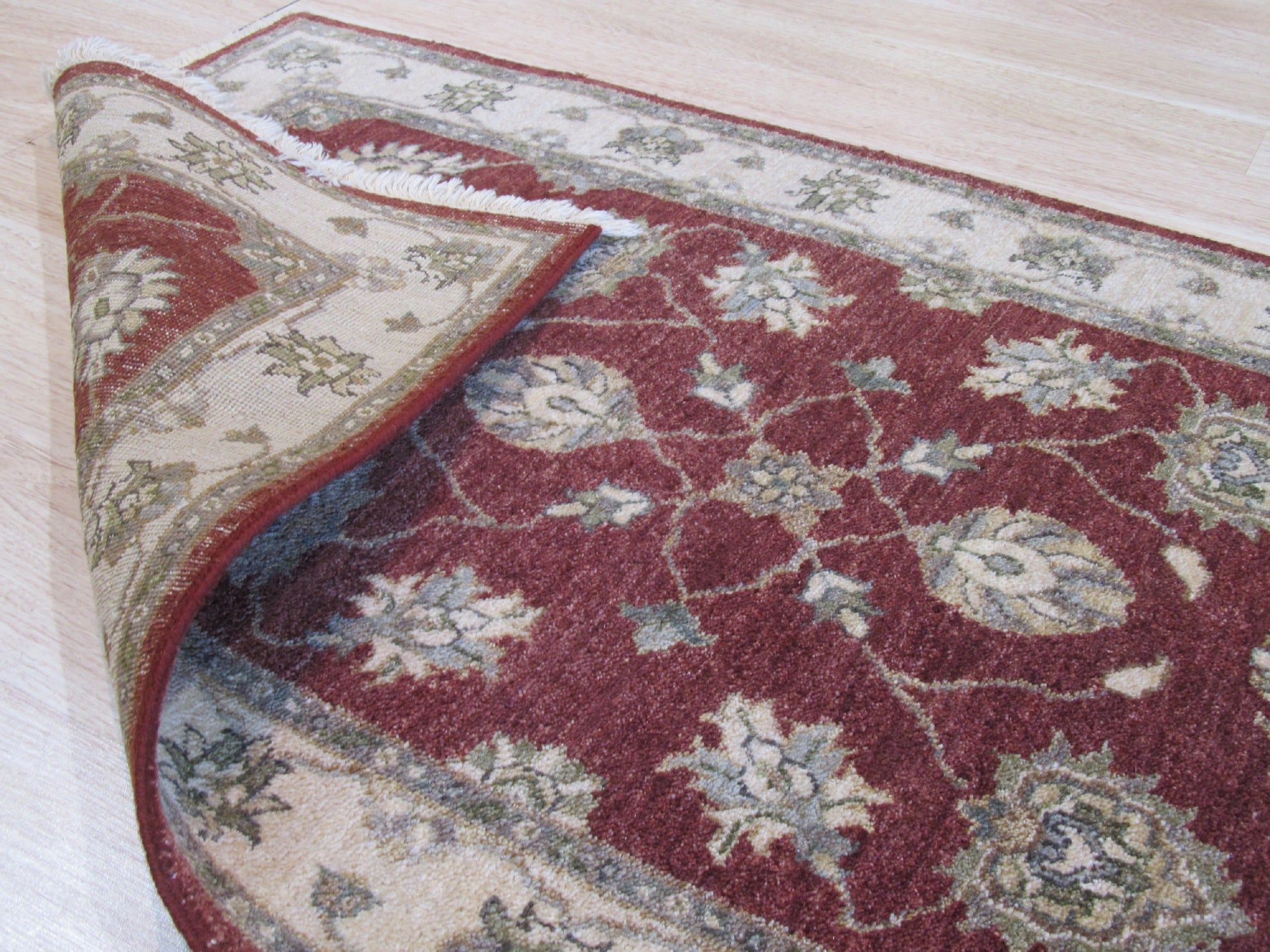 Timeless Oushak Red Hand Knotted Wool Rug, richly detailed with a traditional Oushak pattern in vibrant reds and muted creams, lies elegantly on a polished hardwood floor.