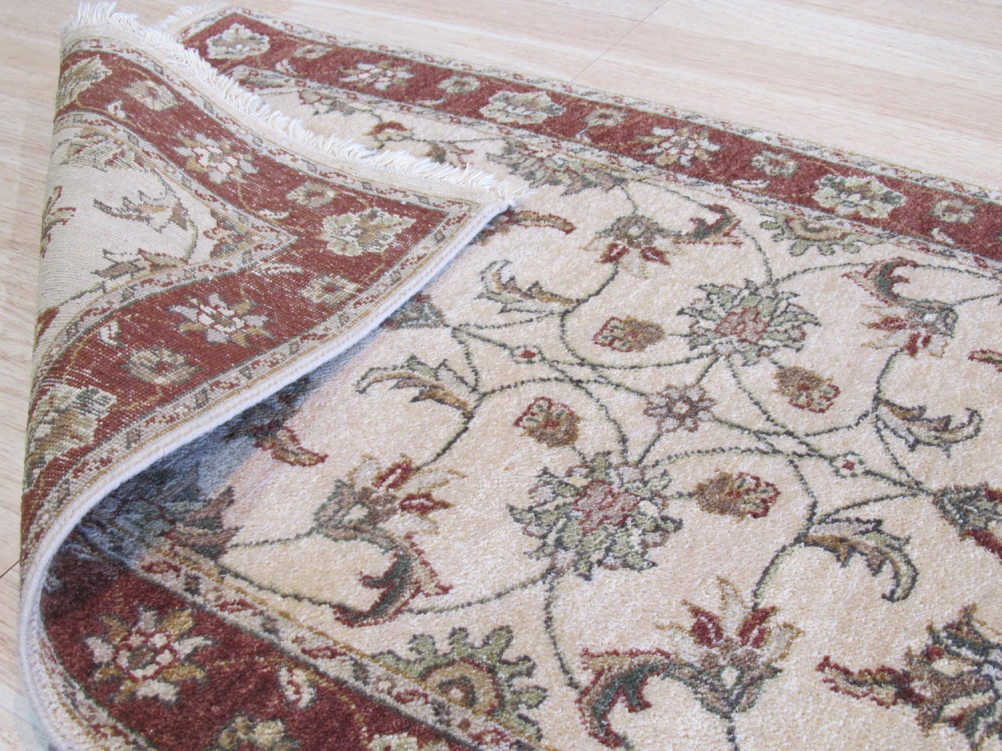 Bianca Agra Ivory Hand Knotted Wool Rug, its intricate, hand-knotted weave and elegant ivory tones lending warmth and sophisticated texture to a well-lit living room.