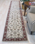 Bianca Agra Ivory Hand Knotted Wool Rug, an ivory wool rug with an intricate, perhaps traditional Agra-inspired design, seen in a room setting suggesting a living or dining space.
