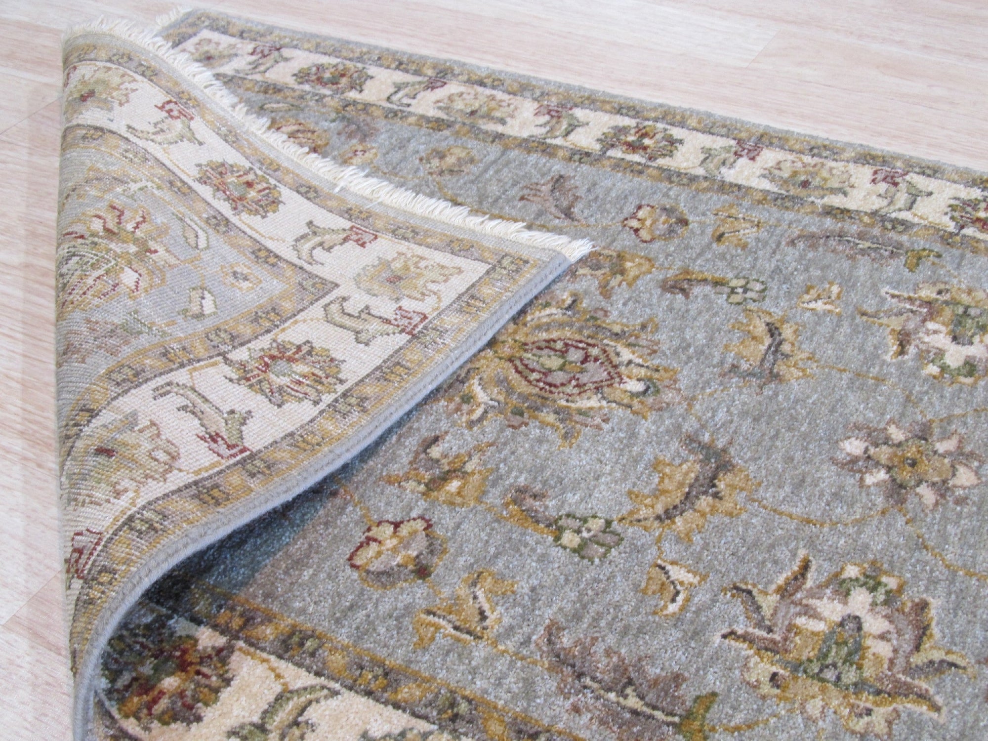 Zinnia Agra Green Hand Knotted Wool Rug, a lush expanse of verdant green wool, hand-knotted with intricate floral patterns, bringing warmth and artisanal craftsmanship to an inviting living space.