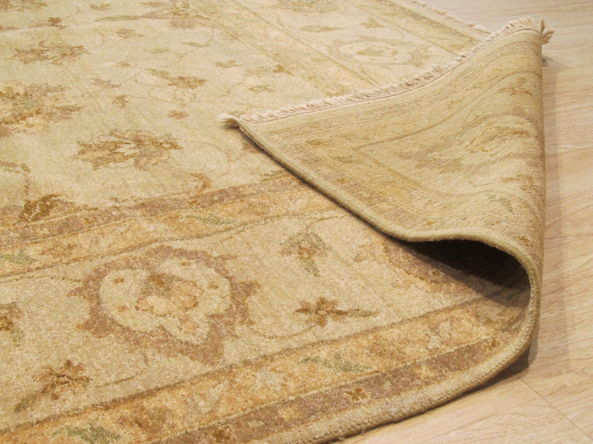 Iris Peshawar Multicolor Hand Knotted Wool Rug displayed on a hardwood floor; vibrant hues blend in a traditional design.