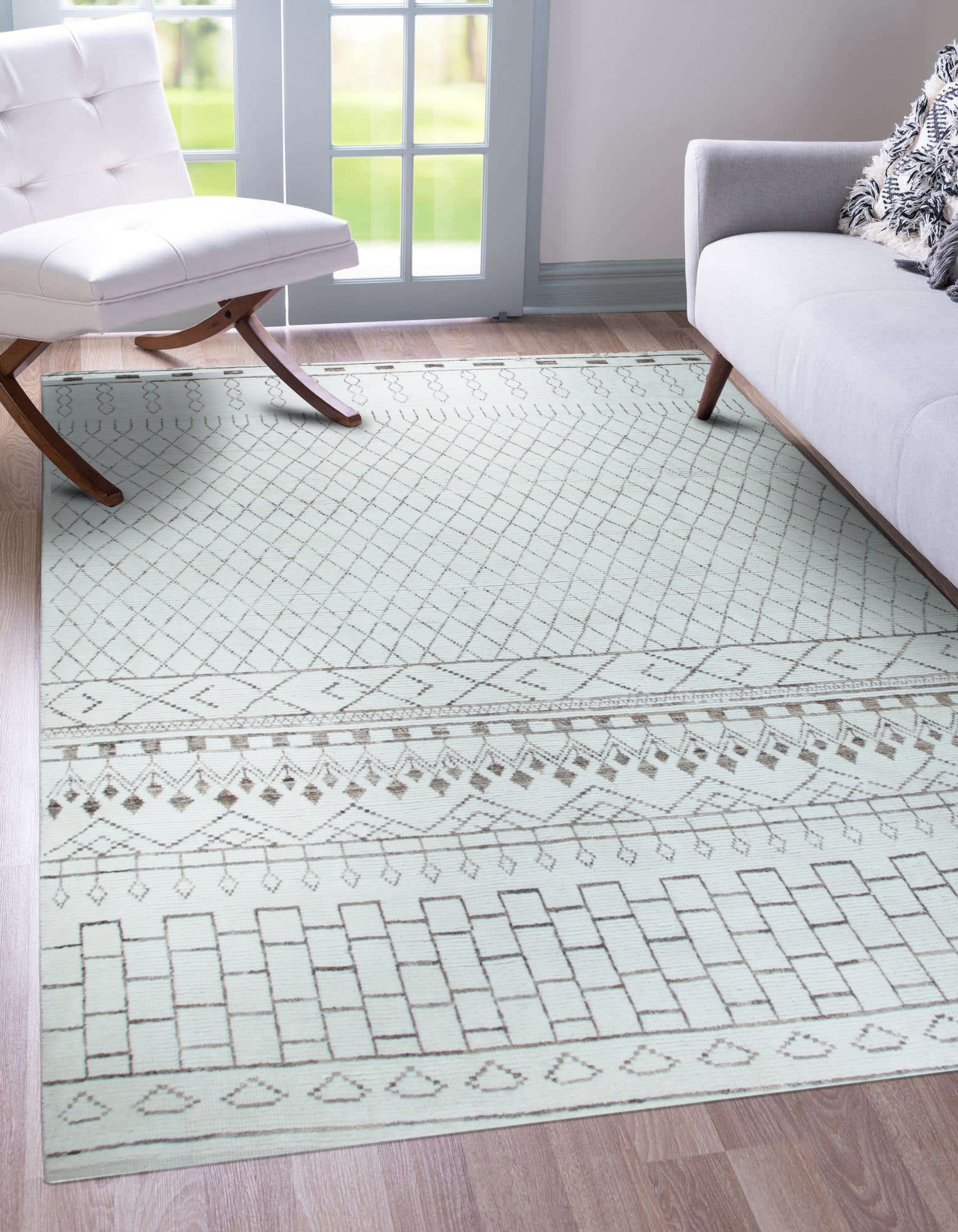 Jasmine Moroccan Ivory Hand Knotted Wool Rug graces a warmly lit living room; soft ivory wool pile showcases the rug's plush texture and Moroccan-inspired geometric design against hardwood flooring.