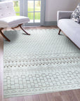Jasmine Moroccan Ivory Hand Knotted Wool Rug graces a warmly lit living room; soft ivory wool pile showcases the rug's plush texture and Moroccan-inspired geometric design against hardwood flooring.