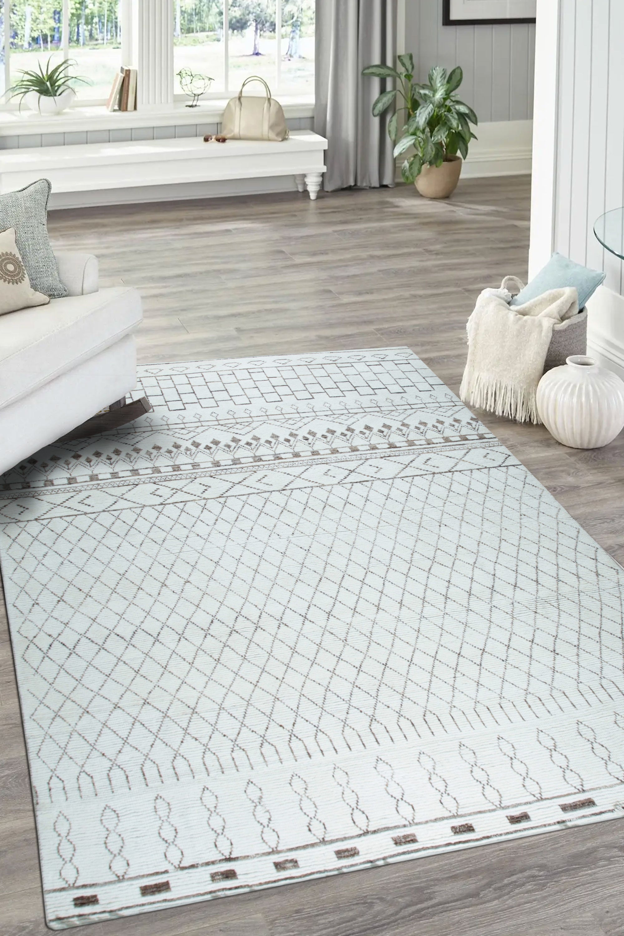 Jasmine Moroccan Ivory Hand Knotted Wool Rug, blending seamlessly into a bright living room with natural light, displays its intricate diamond pattern and soft texture beneath a modern sofa and coffee table.