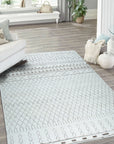 Jasmine Moroccan Ivory Hand Knotted Wool Rug, blending seamlessly into a bright living room with natural light, displays its intricate diamond pattern and soft texture beneath a modern sofa and coffee table.