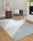 Jasmine Moroccan Ivory Hand Knotted Wool Rug laid on a light wood floor, its textured ivory wool pile and subtle Moroccan-inspired geometric patterns creating a warm and inviting atmosphere.