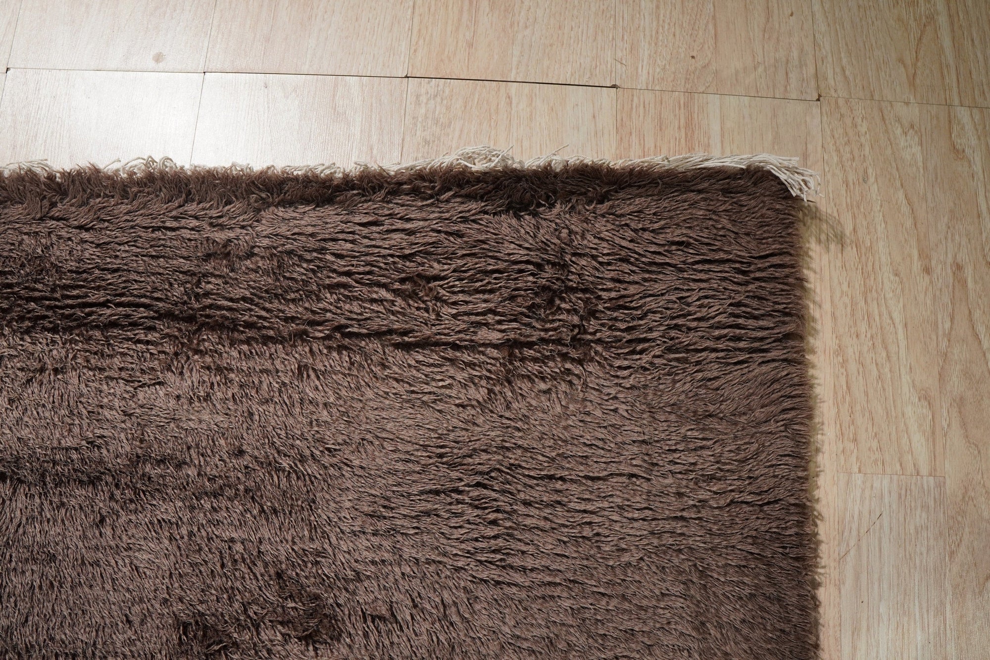 Nadia Mira Brown Hand Knotted Wool Rug, featuring a warm, neutral palette and intricate, traditional patterns. The hand-knotted construction adds depth and texture, complementing the rug's brown tones. Seen as a detail shot emphasizing the weave and intricate design.