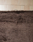 Nadia Mira Brown Hand Knotted Wool Rug, featuring a warm, neutral palette and intricate, traditional patterns. The hand-knotted construction adds depth and texture, complementing the rug's brown tones. Seen as a detail shot emphasizing the weave and intricate design.