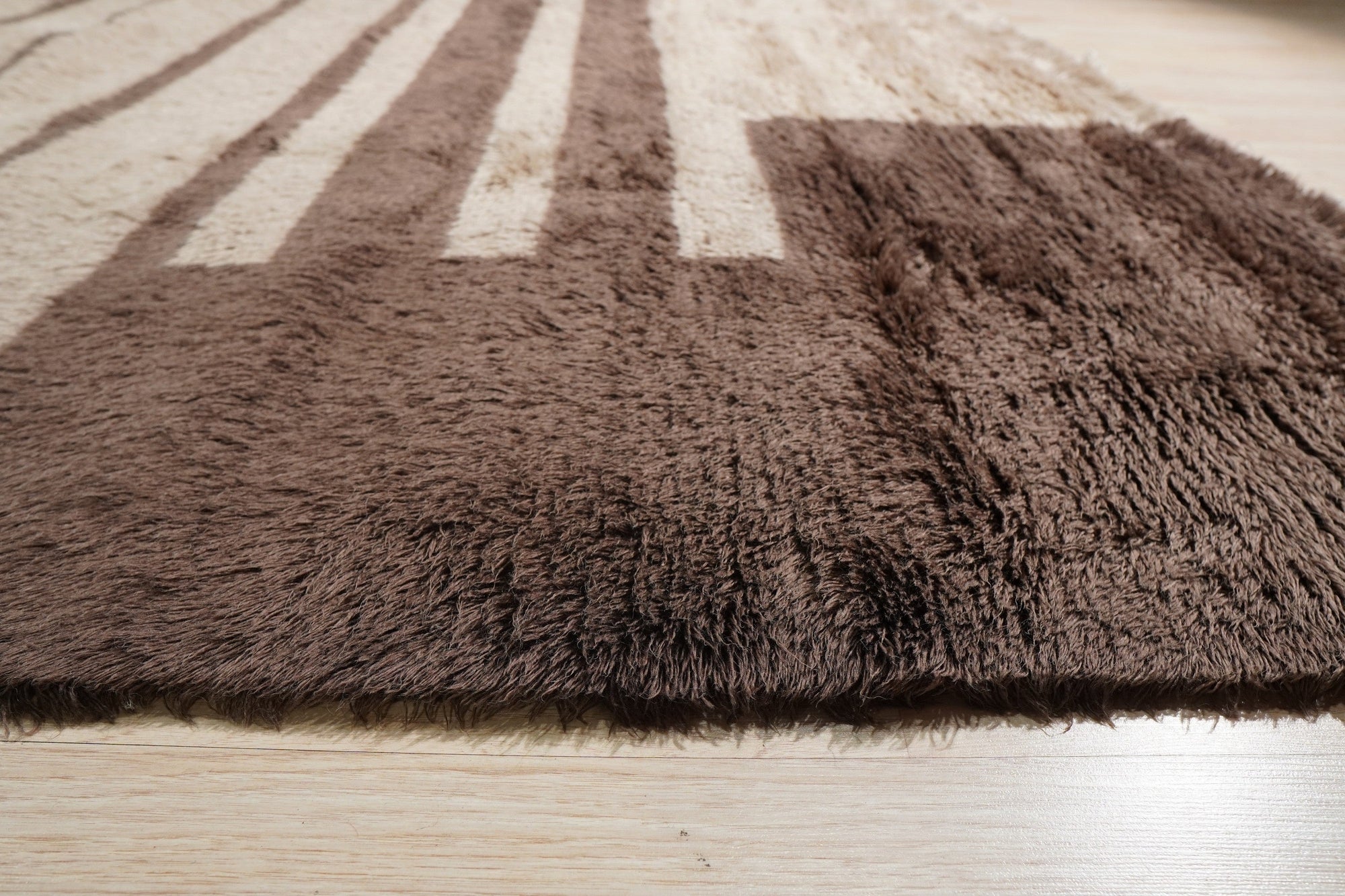 Nadia Mira Brown Hand Knotted Wool Rug, warm brown tones and intricate hand-knotted textures create a welcoming atmosphere in a bright living space.