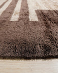 Nadia Mira Brown Hand Knotted Wool Rug, warm brown tones and intricate hand-knotted textures create a welcoming atmosphere in a bright living space.