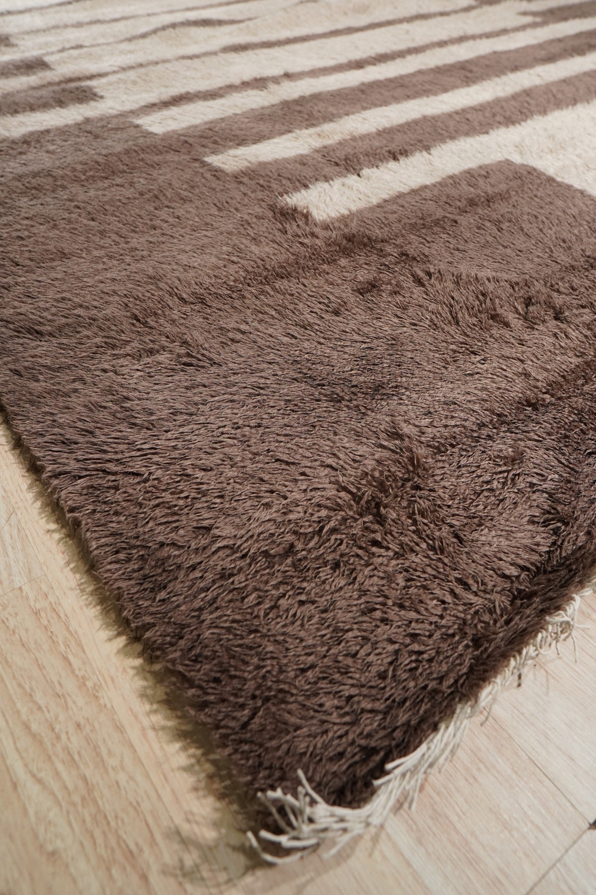 Nadia Mira Brown Hand Knotted Wool Rug in a well-lit room setting, its rich brown tones and intricate hand-knotted texture adding warmth and depth.