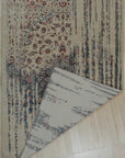 Penelope Elegant Teal Machine Made Wool & Viscose Rug, its luxurious teal and subtle sheen catching the light, lies gracefully on a light wood floor, showcasing its intricate, timeless pattern and inviting texture.