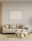 Quinn Artisan Ivory Hand Tufted Wool Rug, a creamy ivory wool rug with a subtle, textured design, displayed in a bright, contemporary living room setting.