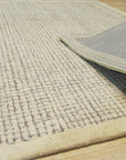 Quinn Artisan Ivory Hand Tufted Wool Rug, its thick, plush ivory wool pile inviting touch, showcased within a bright, airy living space.