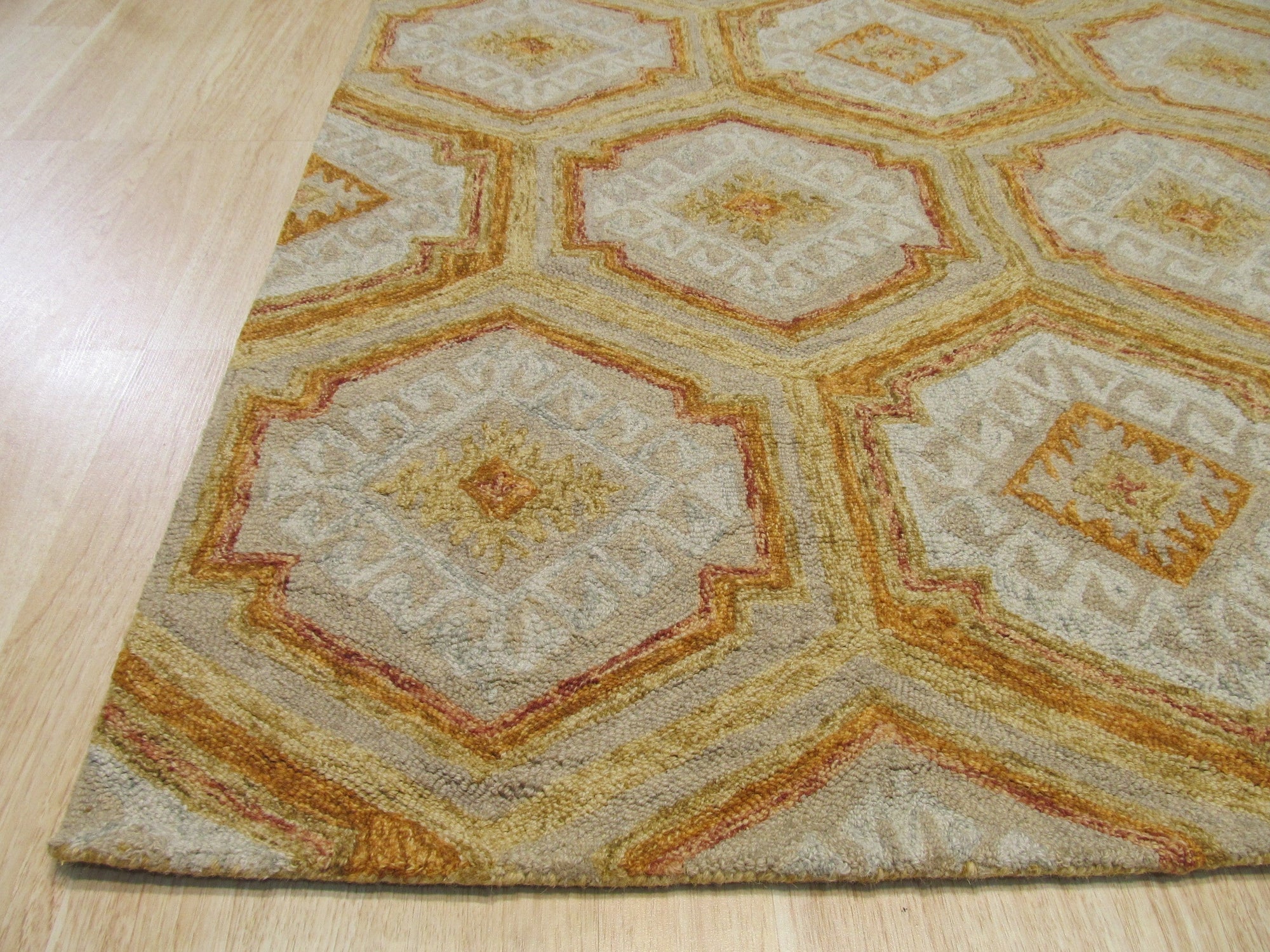 Alluring Laine Gold Hand Tufted Wool Rug, a plush wool rug with subtle gold tones and a textured hand-tufted construction, adding warmth and elegance to a living room setting.
