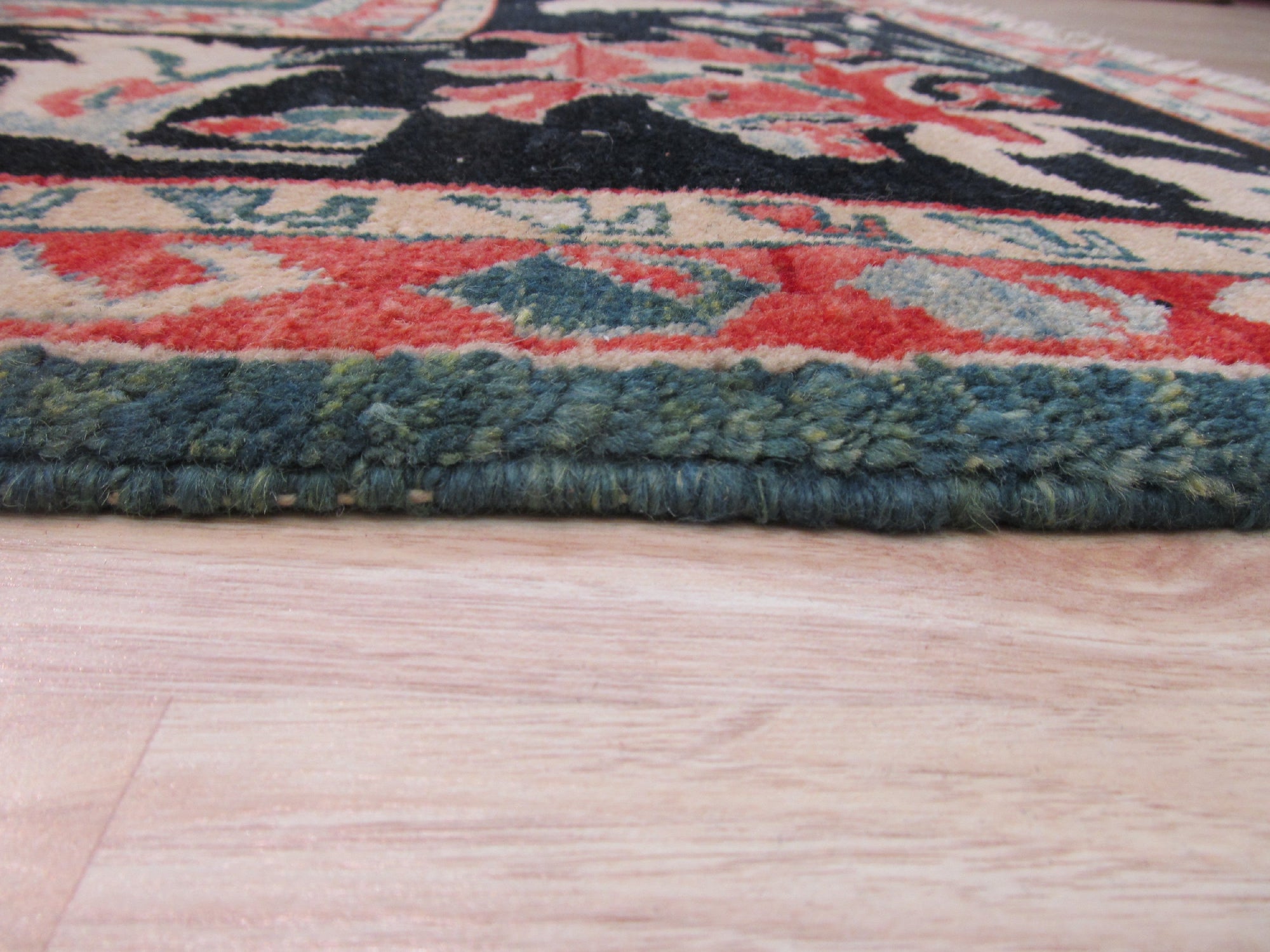 Refined Chic Green Hand Knotted Wool Rug, with its verdant hues and intricate design, graces a light-filled living space. Hand-knotted wool construction offers texture and depth, complementing neutral furniture and adding sophisticated warmth to the room.