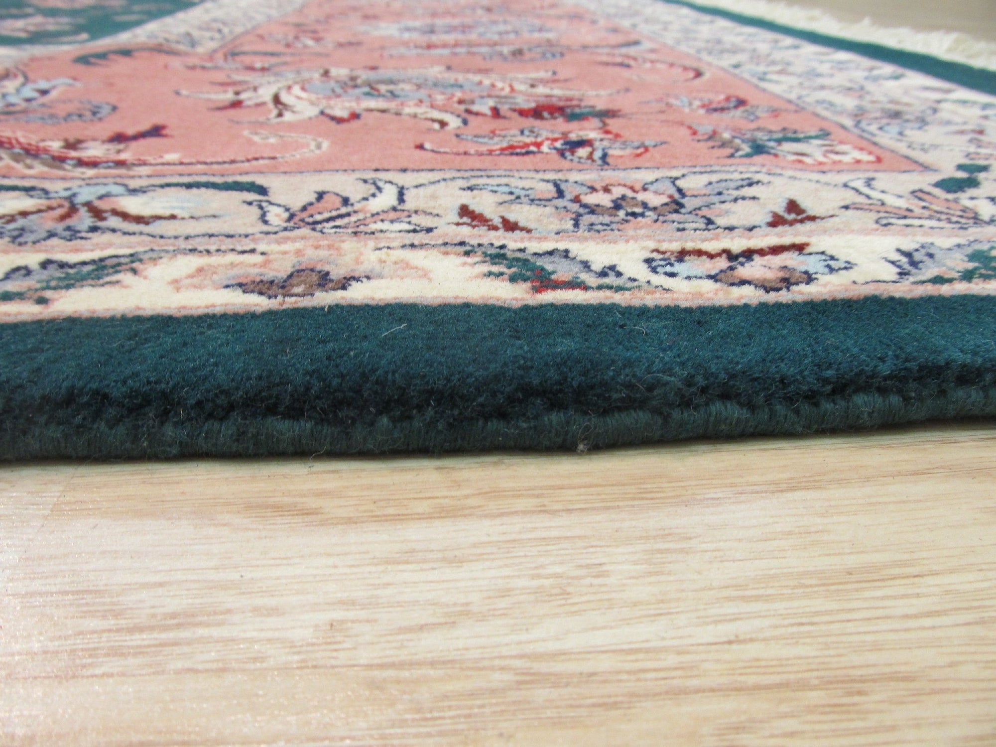 Trara Jasmine Multicolor Hand Knotted Wool Rug, vibrant floral patterns dance across a creamy field, hand-knotted texture adding depth and warmth to a warmly lit living room.