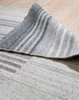 Classic Artistic Gray Flatweave Wool & Viscose Rug, featuring a subtle pattern in shades of gray, lies flat on the floor showcasing its texture and construction.