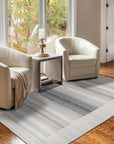 Classic Artistic Gray Flatweave Wool & Viscose Rug, its subtle gray tones and flatweave construction complementing a modern living room with a light wooden floor.