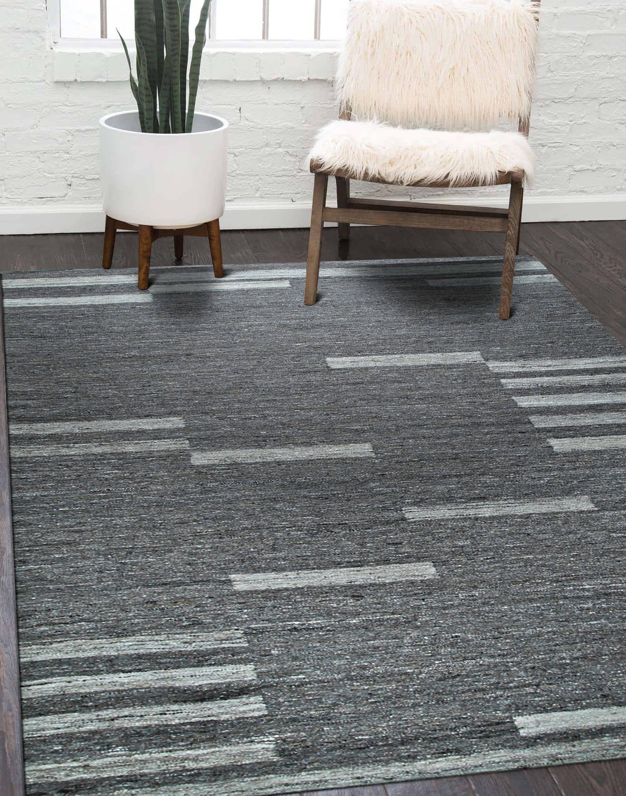 Cassandra Clara Brown Flatweave Wool Rug displayed on a light hardwood floor, its geometric pattern in muted browns and creams creating a sophisticated, grounded aesthetic.