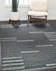 Cassandra Clara Brown Flatweave Wool Rug displayed on a light hardwood floor, its geometric pattern in muted browns and creams creating a sophisticated, grounded aesthetic.