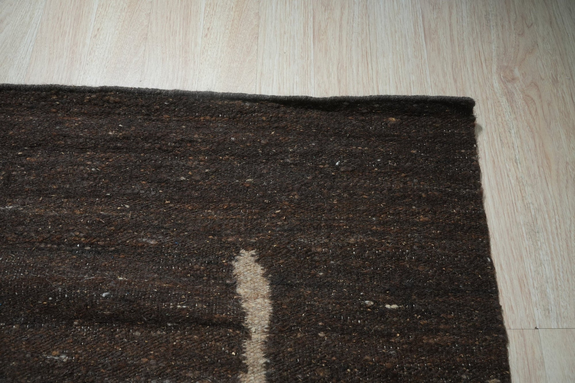 Talia Delicate Brown Flatweave Wool Rug gracing a well-lit living space, its flatweave construction and delicate brown hues complementing the modern decor.