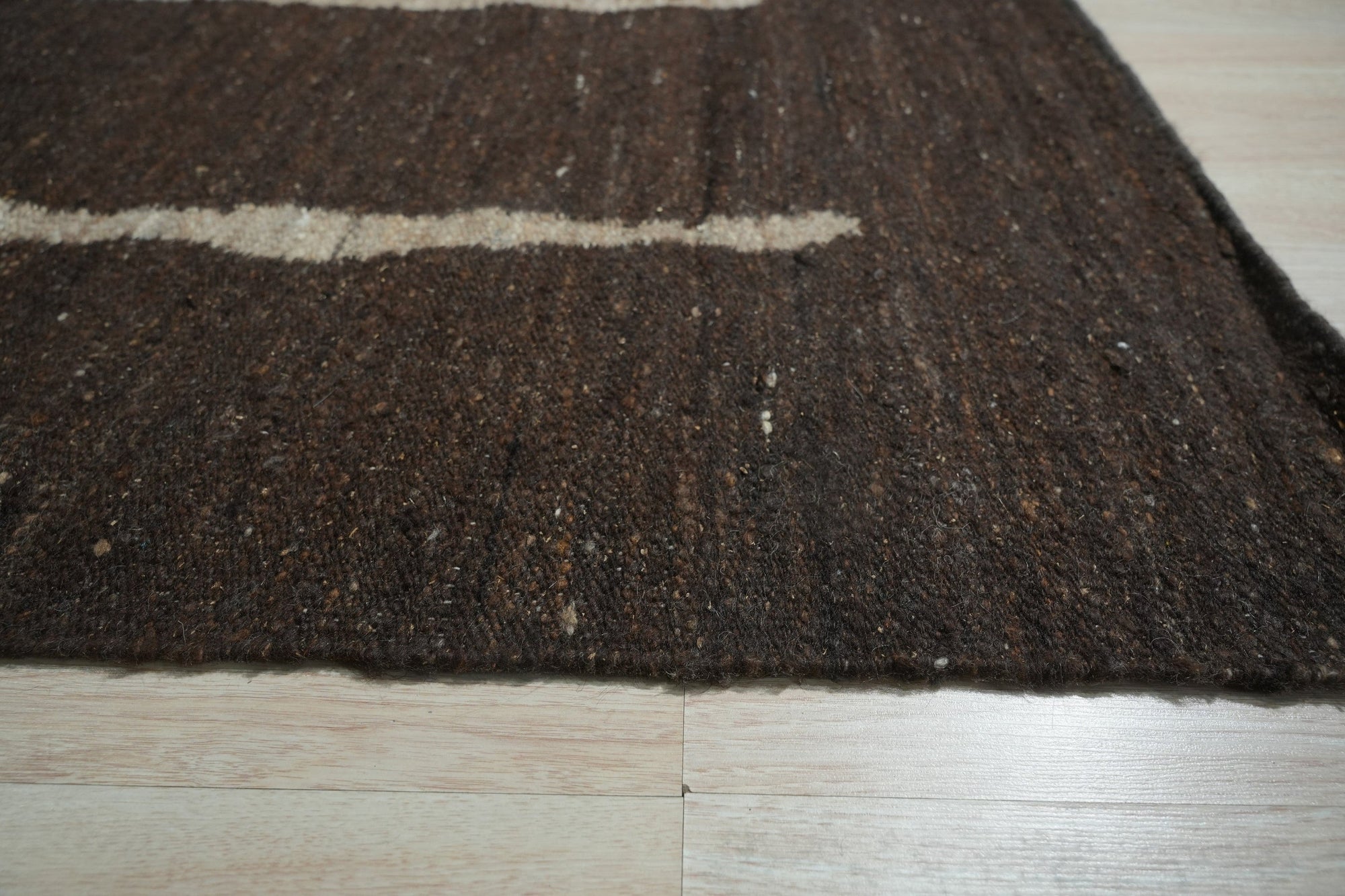 Talia Delicate Brown Flatweave Wool Rug, showcasing its subtle, interwoven texture and warm brown tones within a stylish living room setting.