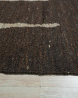 Talia Delicate Brown Flatweave Wool Rug, showcasing its subtle, interwoven texture and warm brown tones within a stylish living room setting.