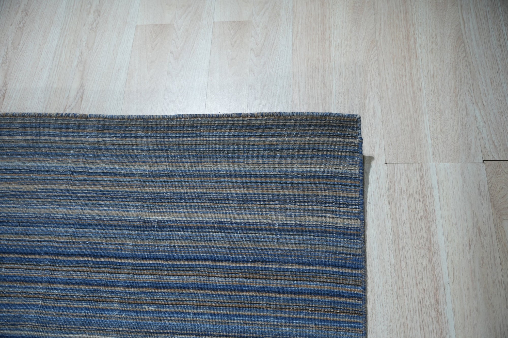 Freya Alluring Blue Handmade Rug, showcasing a blend of cool blues and subtle textures, filling a bright, modern living space.
