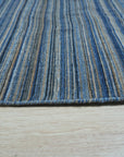Freya Alluring Blue Handmade Rug displayed in a well-lit room, its intricate design and cool blue tones adding a sophisticated touch to the space.