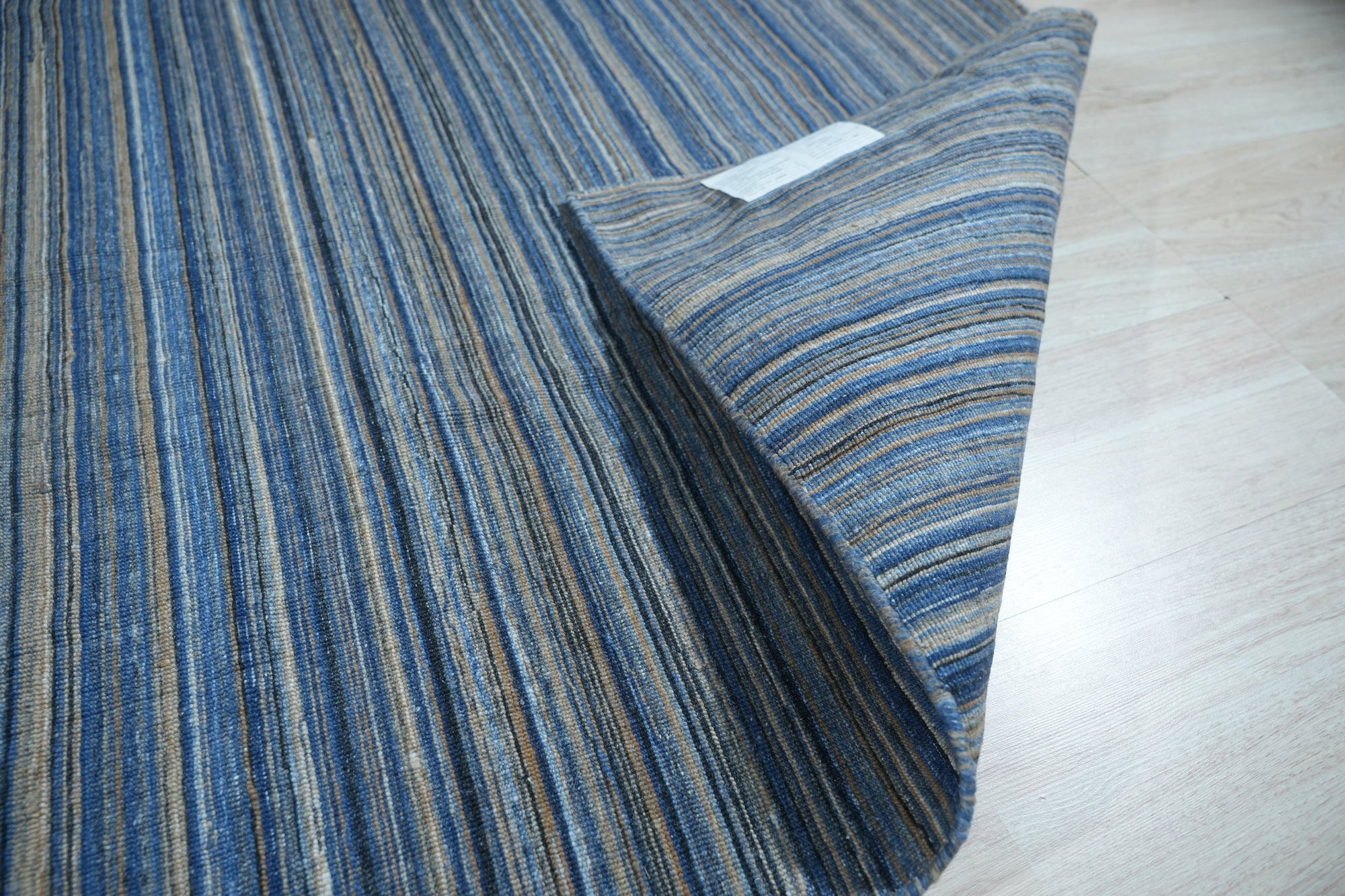 Freya Alluring Blue Handmade Rug, showcasing deep blues and swirling patterns reminiscent of ocean depths; luxuriously textured, enriching a modern living space.