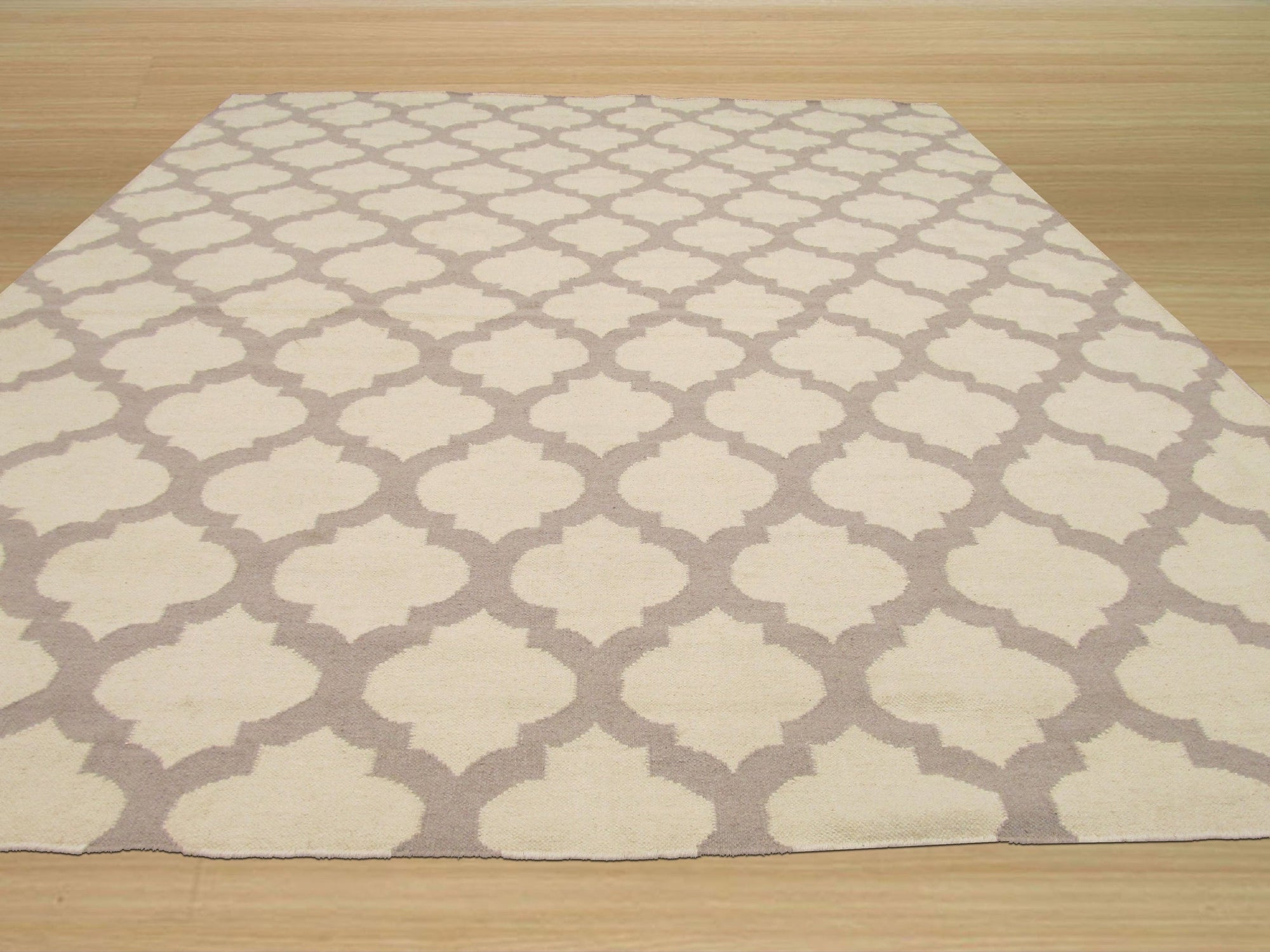 Maya Moroccan Ivory Flatweave Wool Rug, a textural landscape of geometric motifs in soft ivory wool, lends warmth and subtle pattern to a living space.