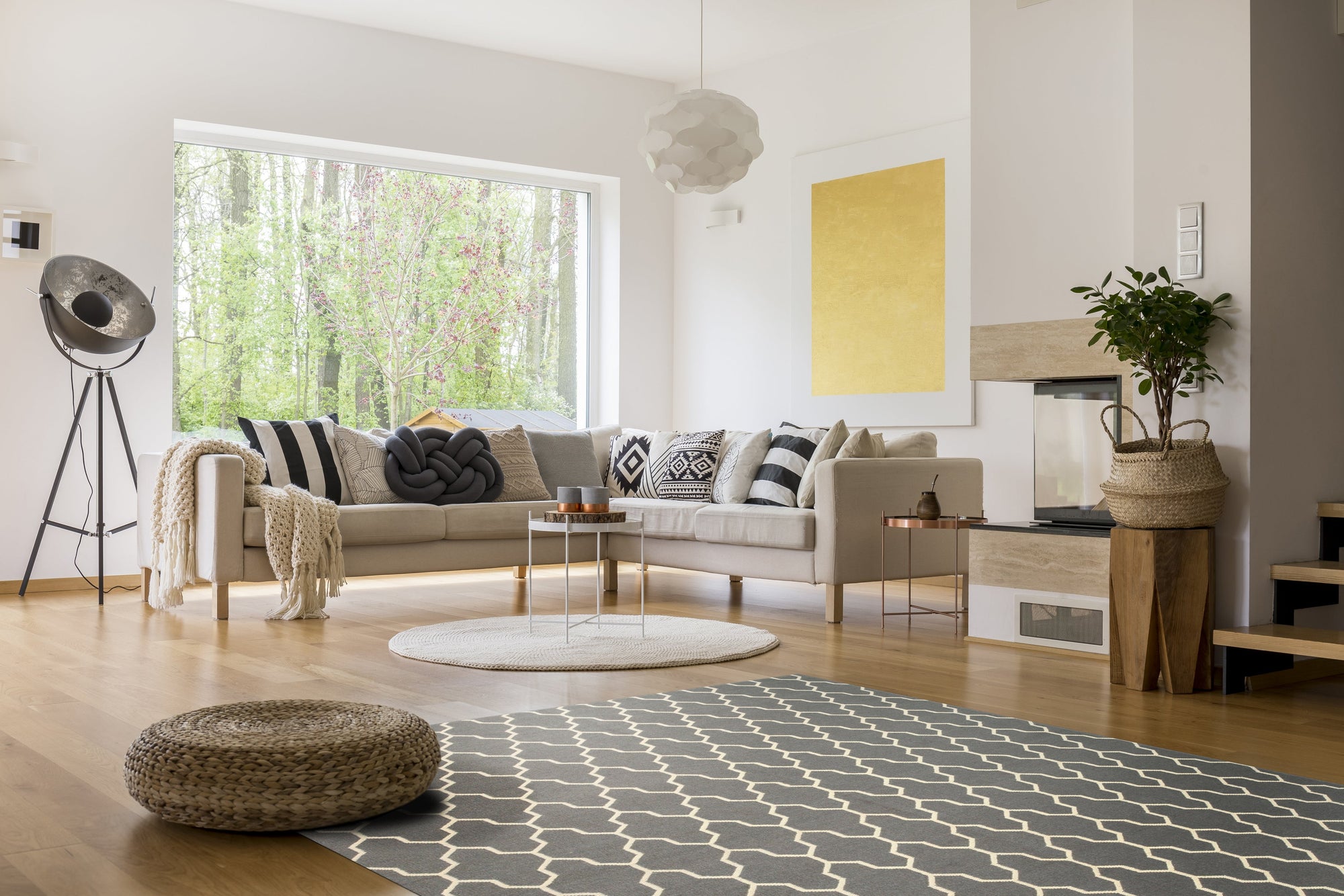 Classic Moroccan Gray Flatweave Wool Rug, showcasing a simple geometric pattern in shades of gray and ivory, lies flat on a light wood floor, adding subtle texture to a minimalist space.