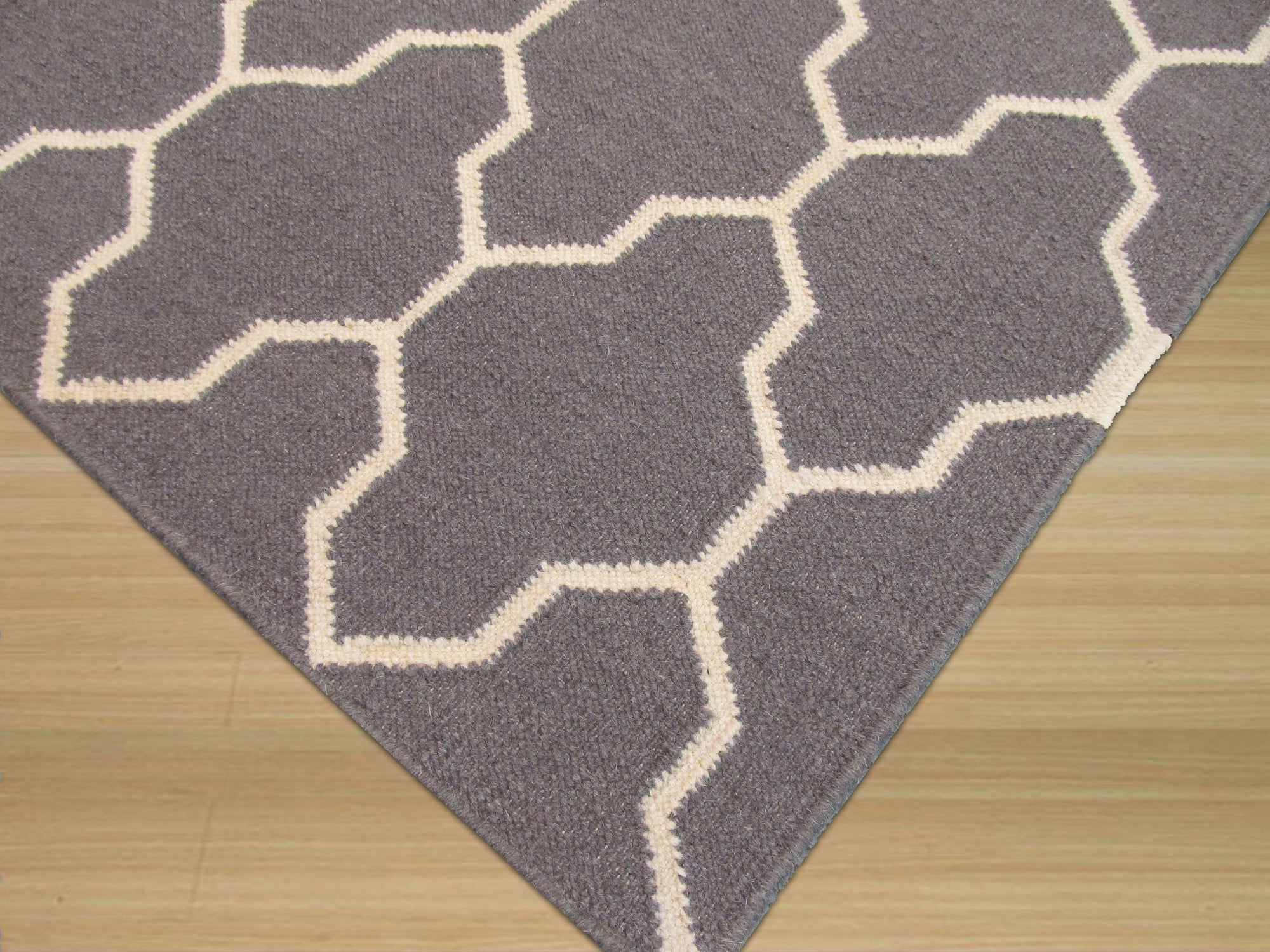 Classic Moroccan Gray Flatweave Wool Rug, lying flat on a light surface, showcasing its subtle geometric diamond pattern in shades of gray. Soft woven wool texture visible under ample natural light.