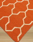 Classic Moroccan Orange Flatweave Wool Rug, showcasing its vibrant orange hues and intricate flatweave construction, displayed in a bright, naturally lit living space with neutral furniture.
