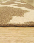 Iris Moroccan Brown Flatweave Wool Rug, seen in a bright, airy living room setting. Warm brown tones and a subtle geometric pattern of the flatweave wool rug complement a modern sofa and natural light streaming through a window.