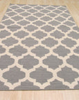 Selene Elena Gray Flatweave Wool Rug, showcasing a subtle geometric pattern in soft grays, lays flat in a brightly lit living space with contemporary furniture.