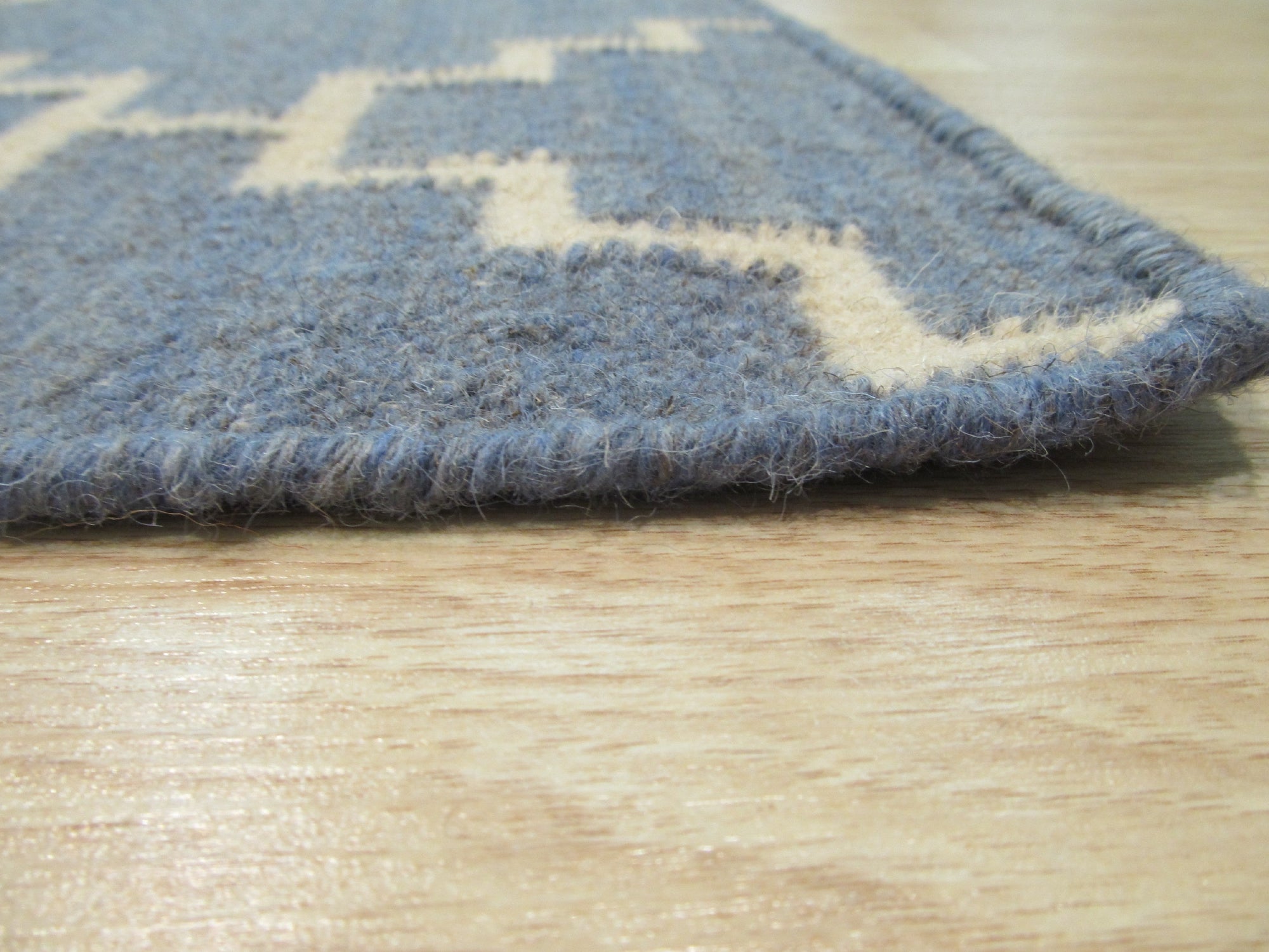 Alluring Bianca Blue Flatweave Wool Rug laid in a bright living room, its cool blue tones and flatweave construction complementing the modern decor and light wood flooring.
