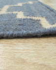 Alluring Bianca Blue Flatweave Wool Rug laid in a bright living room, its cool blue tones and flatweave construction complementing the modern decor and light wood flooring.