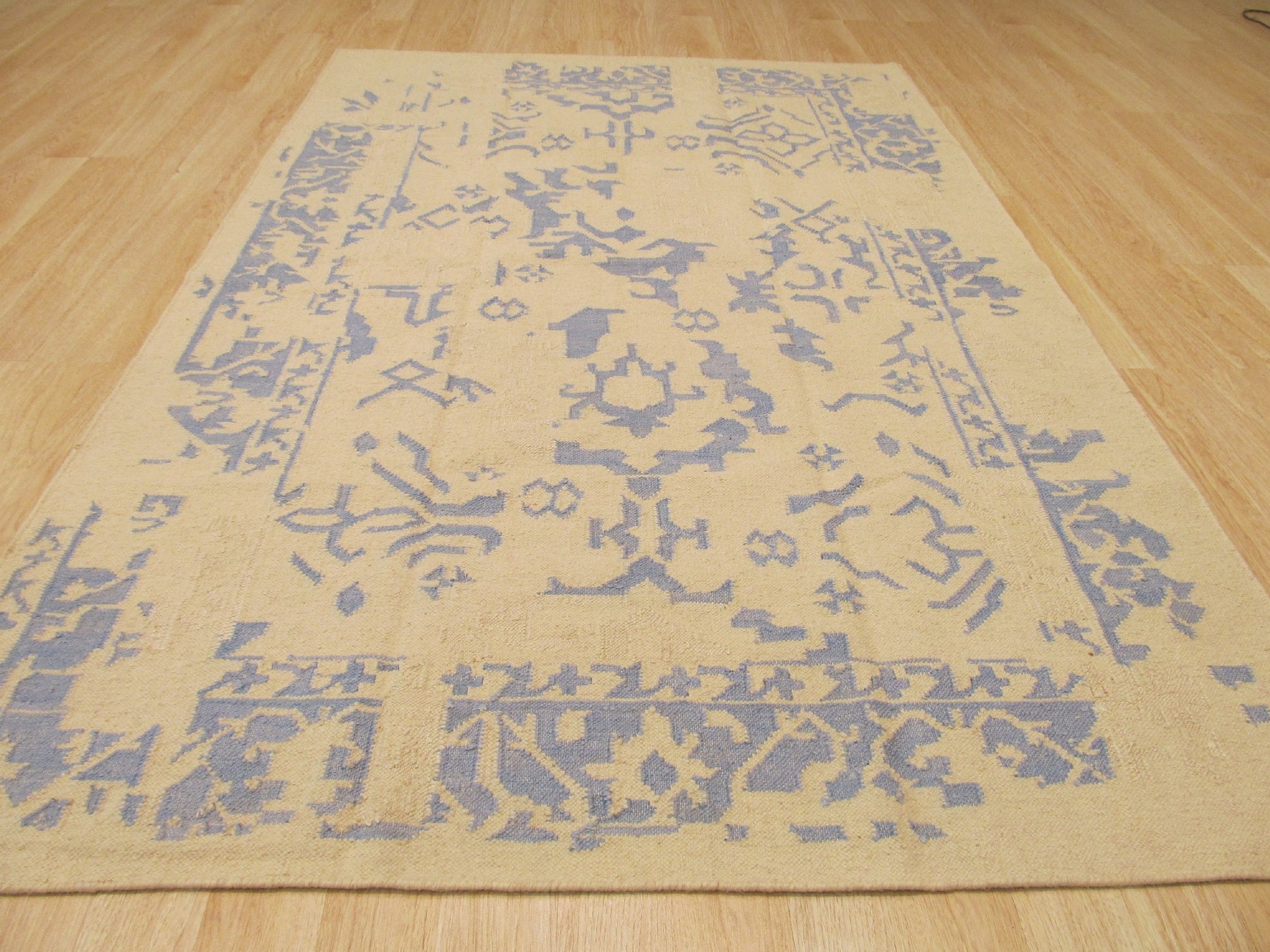 Stylish Graceful Blue Flatweave Wool Rug, a calming wash of blue and cream wool in a subtle geometric flatweave, anchors a bright, airy living space with a modern aesthetic.