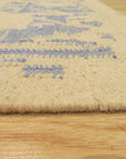 Stylish Graceful Blue Flatweave Wool Rug in a living room setting, its cool blue tones anchoring a seating area with mid-century modern furniture. Soft light highlights the flatweave construction and subtle texture.