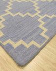 Ruby Moroccan Blue Flatweave Wool Rug, blending deep blues and intricate patterns in a flatweave wool construction, anchors a softly lit living space.