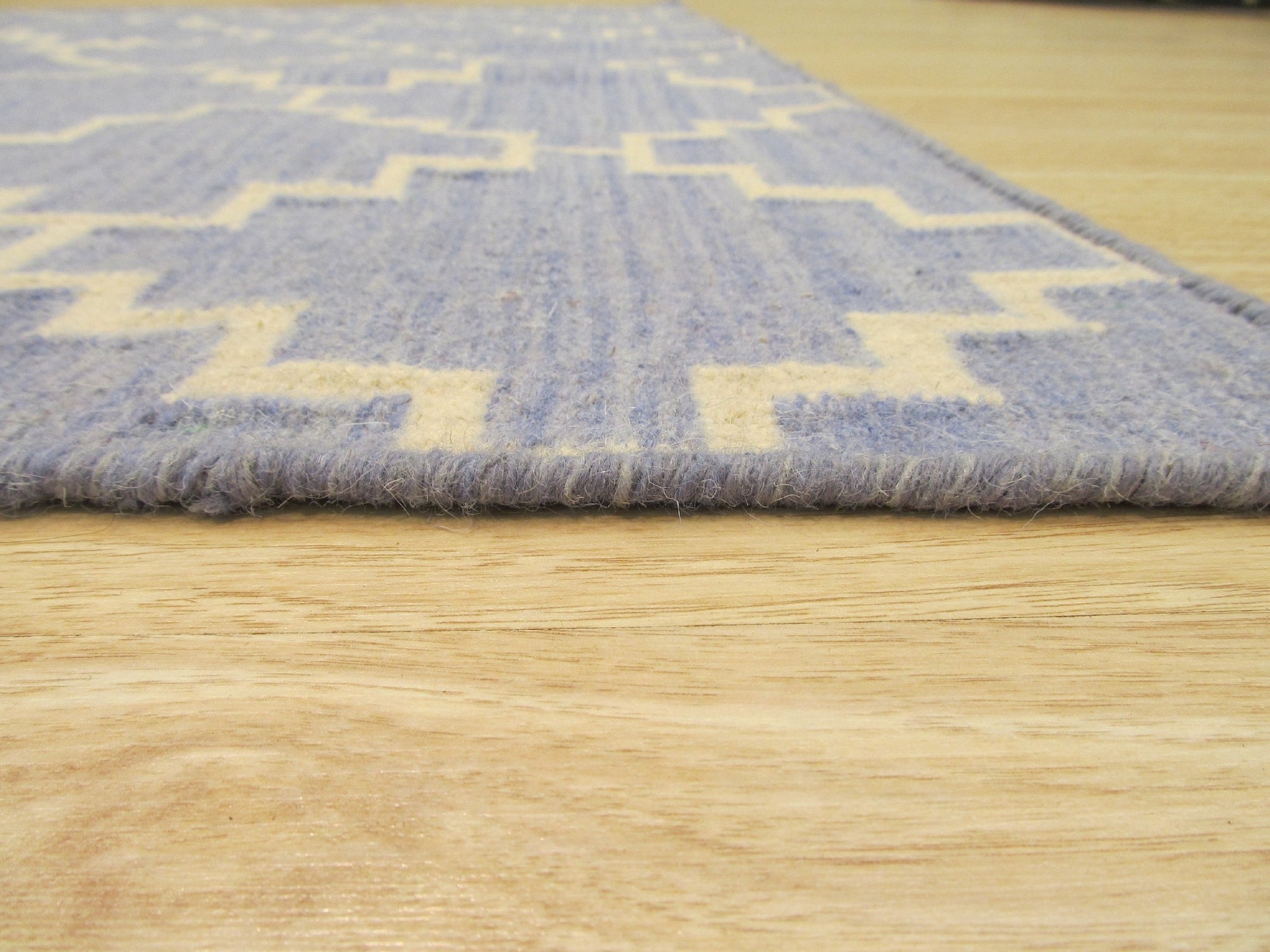 Ruby Moroccan Blue Flatweave Wool Rug, a vibrant blue flatweave wool rug with geometric Moroccan patterns, showcased in a bright, modern living space.